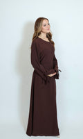 Braunes Kleid mit Perlenbesatz an der Hüfte in Frontansicht mit eleganter Linienführung