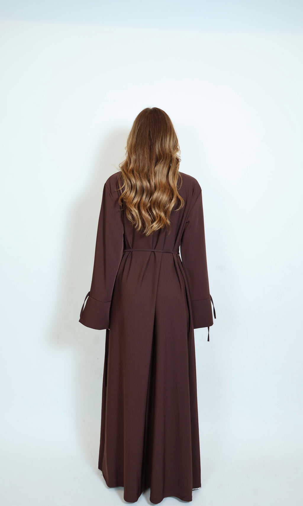 Braunes Kleid von hinten mit fließender Silhouette und stilvollem Design