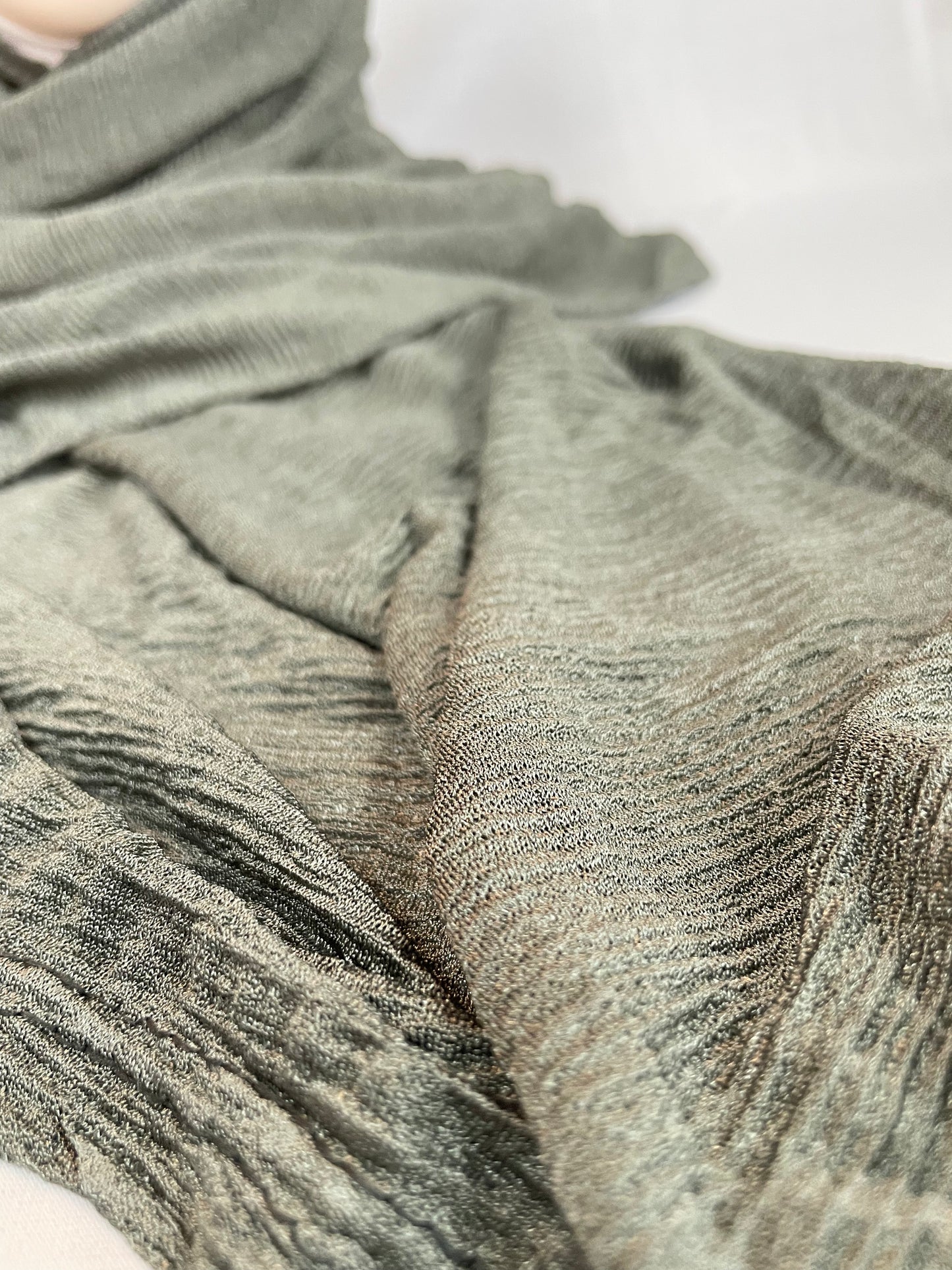 Grüner Hijab aus Kaschmir – Stoffstruktur und Farbe Nahaufnahme