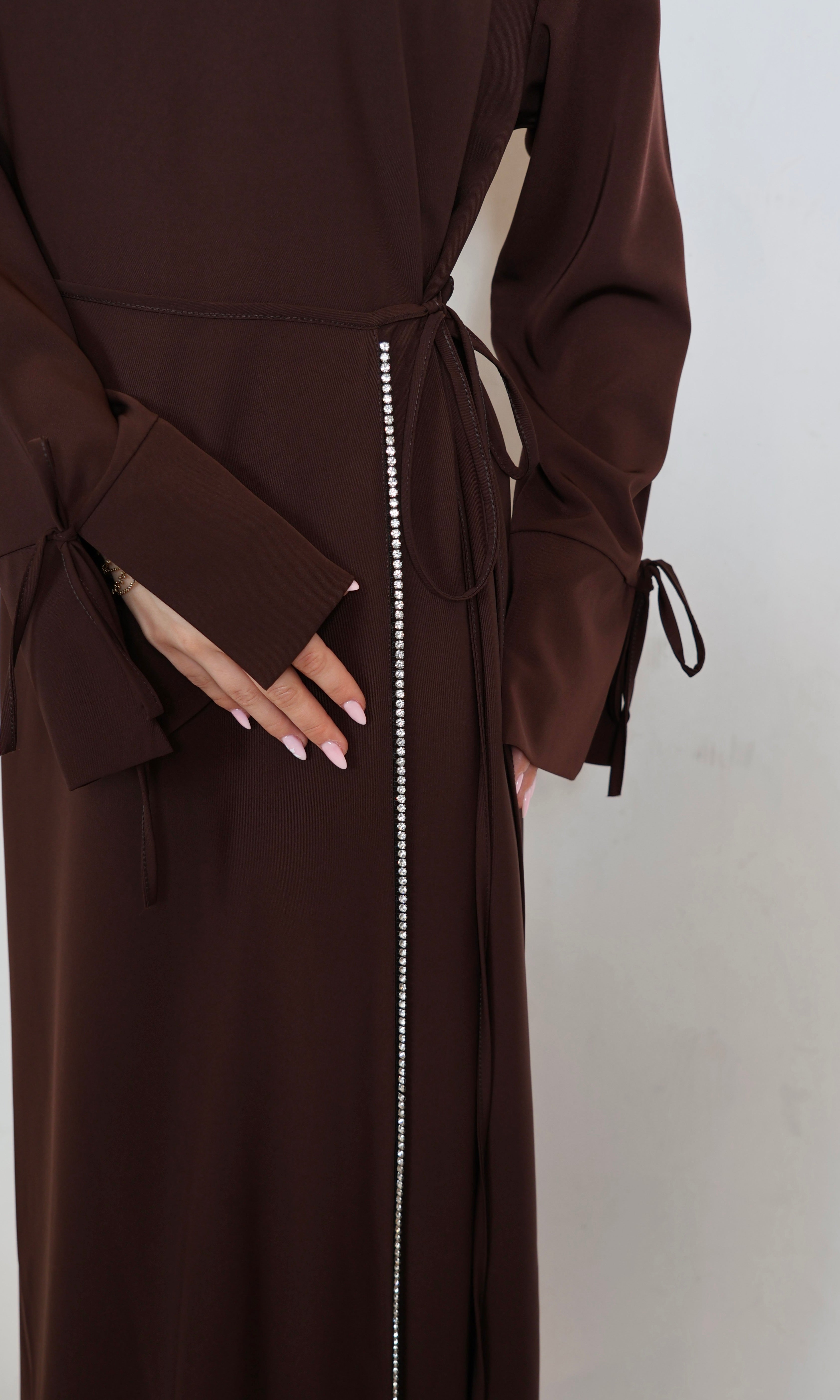 Nahaufnahme des Perlenbesatzes an der Hüfte eines braunen Damenkleides